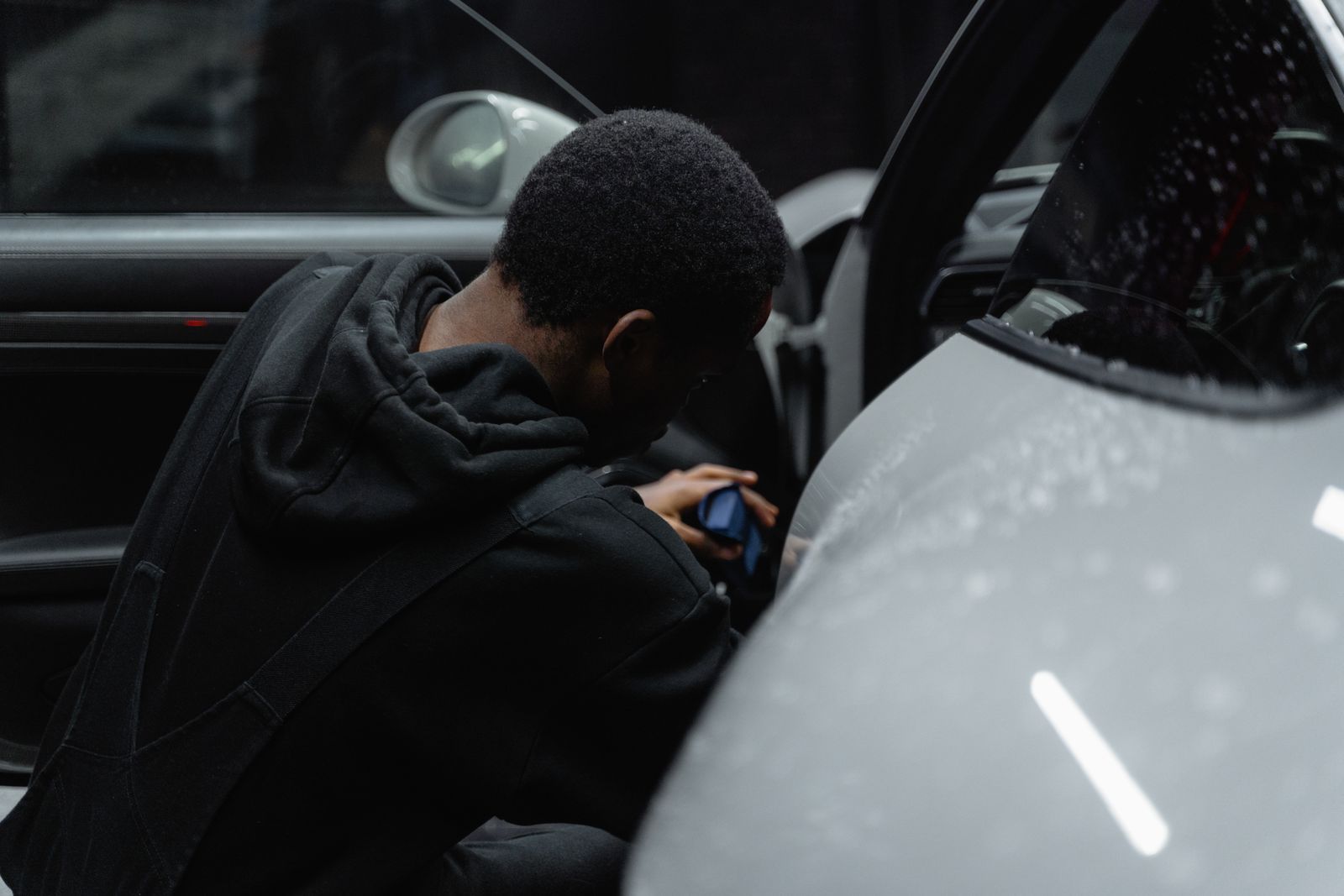 Technician detailing a luxury car interior by hand